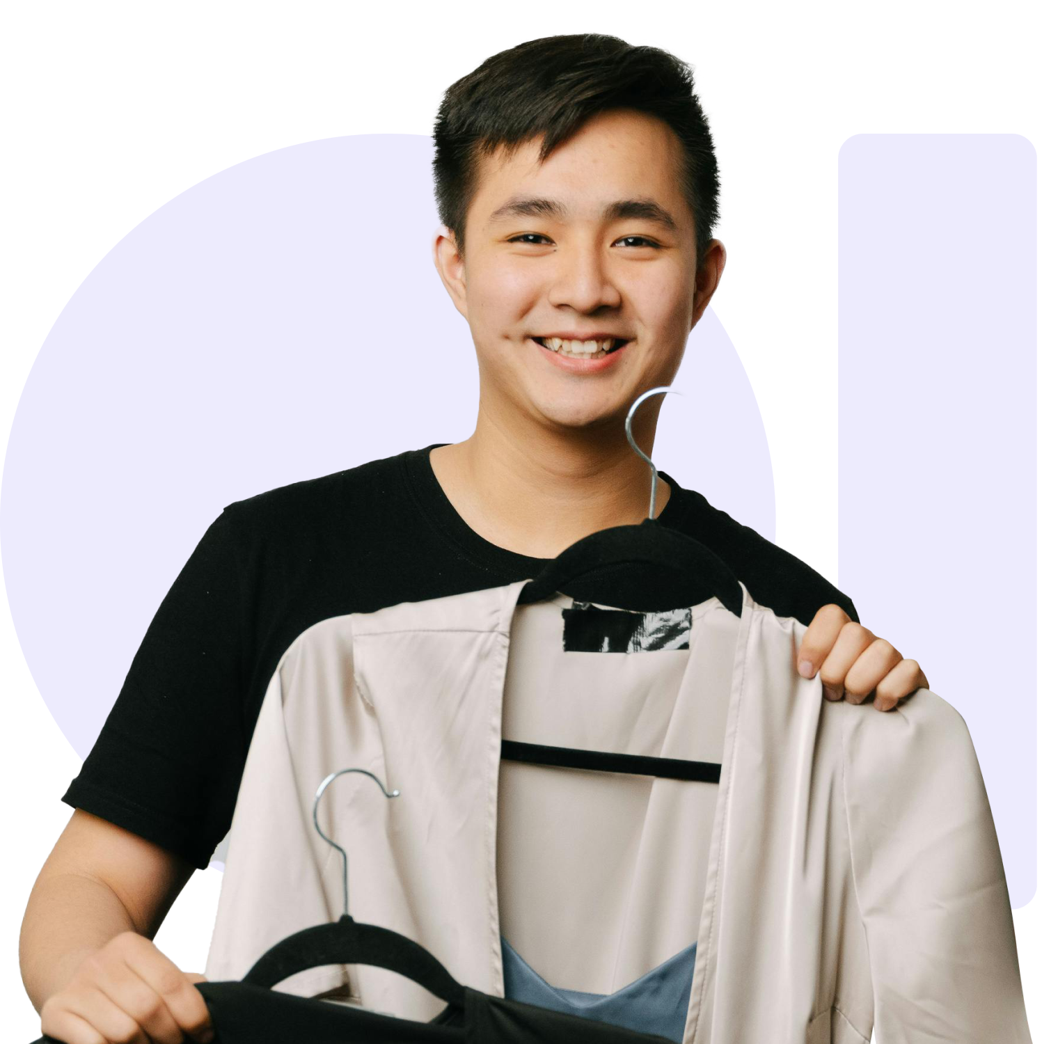 Young person smiling, holding beige jacket and black clothing on hangers.